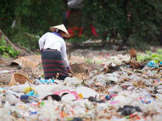Burmeese Volunteer cleaning the plastic mountain of garbish in Myanmar
