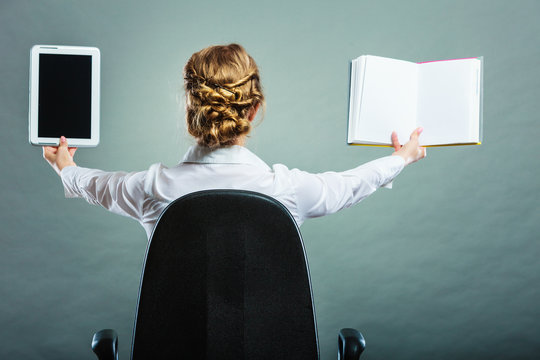 Woman holding traditional book and e-book reader
