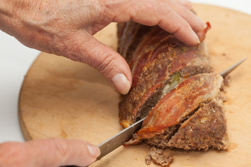 Cortando un rollo de carne asado con tocineta