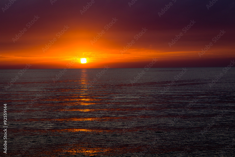 Wall mural beautiful landscape with sunset over sea with dramatic sky