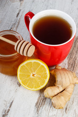 Fresh lemon with honey and cup of tea on wooden table, healthy nutrition