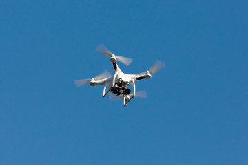 Drone hovering on the blue sky.
