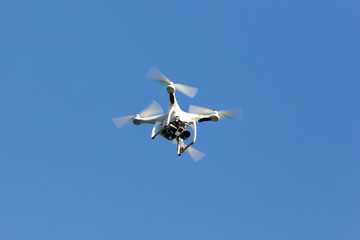 Drone hovering on the blue sky.