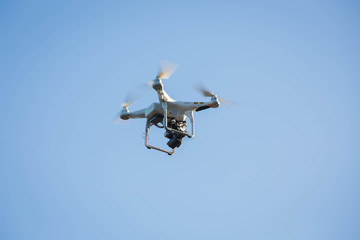Drone hovering on the blue sky.