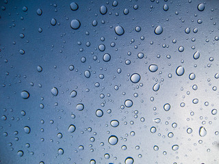 Water drops on glass on blue background