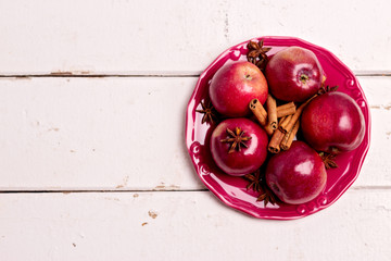 Red apples and spices on the plate.