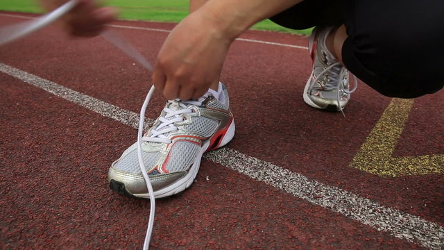 woman runner tying shoelace