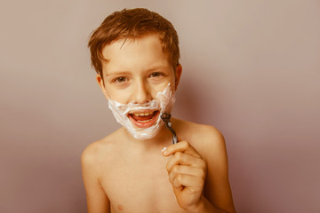 Obraz premium Boy teenager European appearance decade shaves face on a gra