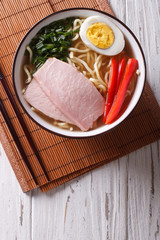 Asian Food: Ramen noodles with pork and egg in a bowl. vertical top view
