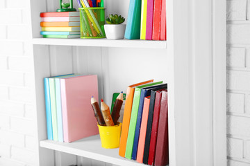 Books and decor on shelves in cupboard © Africa Studio