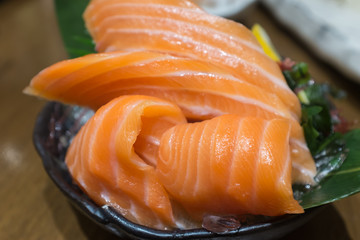 Salmon Sashimi over ice on black bowl