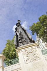 View of the iconic Queen Mother (Queen Elizabeth) Memorial statue by Philip Jackson dressed in robes atop a plinth of Portland stone decorated with UK Coat of Arms, the Mall, Royal London