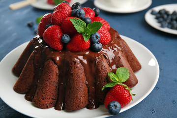 Delicious chocolate cake with strawberries in plate on table, closeup
