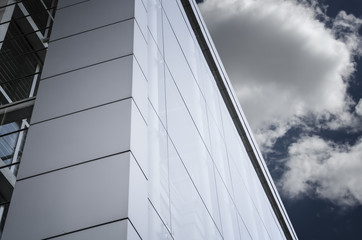Fototapeta na wymiar Detail of glass facade of modern office building with blue sky a