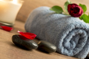 Fototapeta na wymiar Romantic atmosphere with a red rose on top of rolled towel, lit