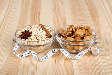 flakes, star anise, cinnamon, and oatmeal in a bowl and a measuring tape on wooden background