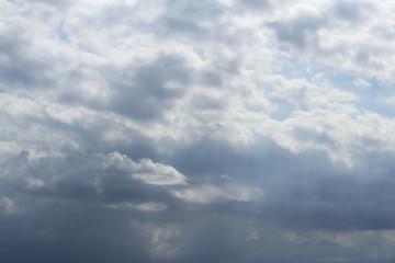 Blue sky seen through thick clouds and the clouds