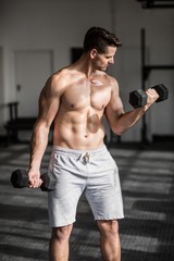 Fototapeta na wymiar Muscular serious man doing weightlifting