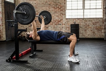 Side view of a man lifting barbell