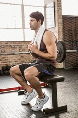 Obraz na płótnie Canvas Muscular man sitting on bench