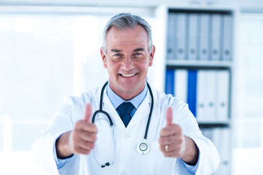 Portrait of doctor showing thumps up sign in clinic