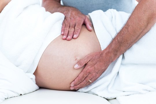 Cropped image of masseur massaging pregnant woman