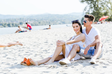Fototapeta premium Romantic young couple sitting at a beach