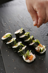 Sushi rolki.Klasyczne  grube rolki futomaki podane na kamiennym talerzu