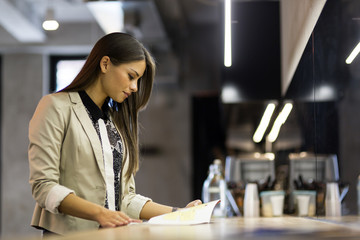 Beautiful woman reading the menu on a counter