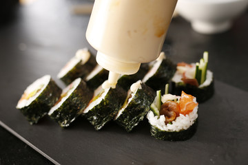 Sushi menu. Klasyczne  grube rolki futomaki podane na kamiennym talerzu