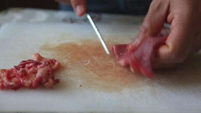 Mani di uomo tagliano una fettina di carne bovina