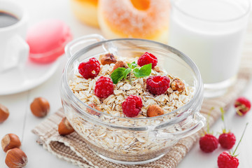 Healthy breakfast, oatmeal muesli on table with coffee and doughnuts.