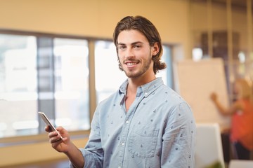Portrait of confident businessman texting on phone