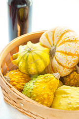 Crop of many small different pumpkins in wicker basket.