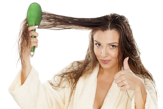 Woman In Bathrobe Brush Her Moist Hair And Showing Thumbs Up