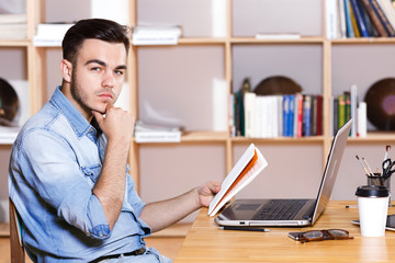 Side view of man sitting at the table with laptop