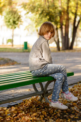 Girl sitting on a bench the park in autumn