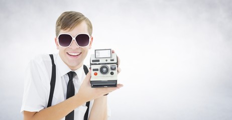 Composite image of geeky hipster holding a retro camera