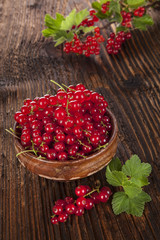 Red currant on wooden background.