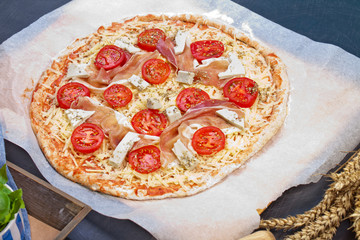 Home made raw pizza with prosciutto and blue cheese. The dough w