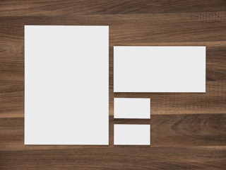 Blank paper, envelope and business cards on wooden background.