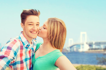 Fototapeta premium couple kissing and taking selfie over bridge