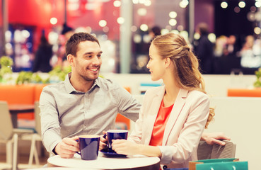 happy couple with shopping bags drinking coffee