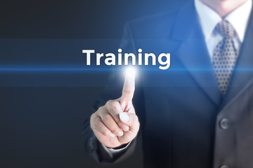 A Businessman holding a white sign with the message training. Can bring to the medium of your ad.