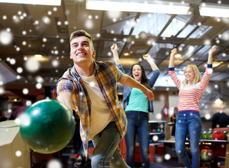Fototapeta na wymiar happy young man throwing ball in bowling club