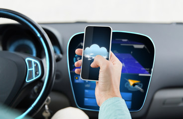close up of male hand with smartphone driving car