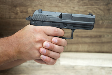 &Mu;asculine hand holding pistol gun