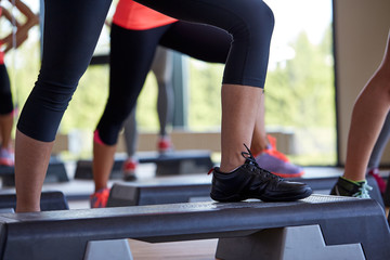 close up of women exercising with steppers in gym