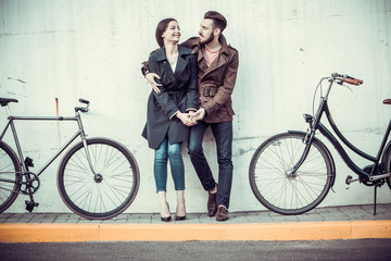 Obraz premium Young couple with a bicycle opposite city 