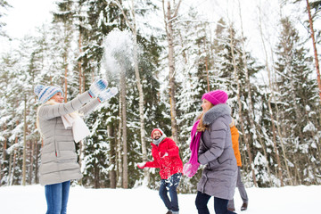 group of smiling men and women in winter forest